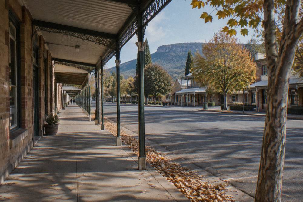 Historic sandstone buildings along a quiet heritage village street on a clear day