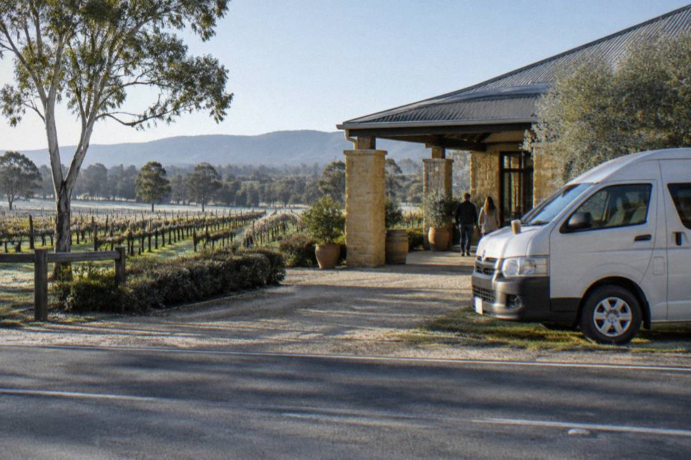 Small tour van parked beside a cellar door entrance in the Hunter Valley