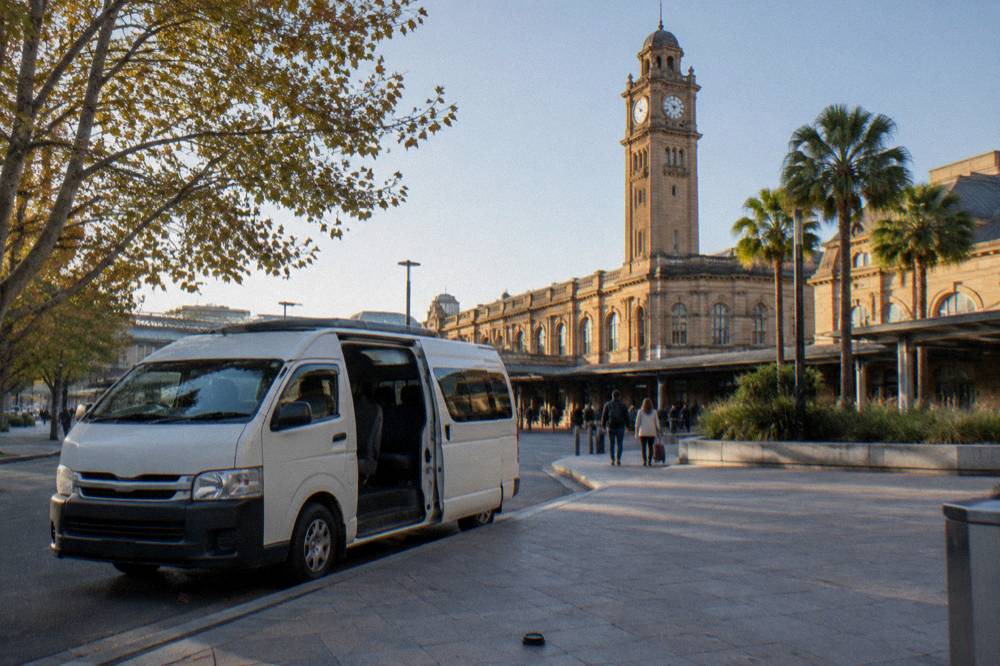 A small tour van parked outside a Hunter Valley cellar door on a sunny afternoon