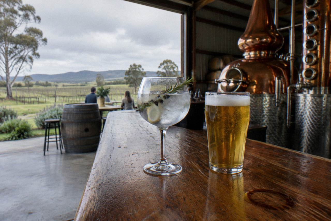 Glasses of gin and beer on a timber bar top inside a Hunter Valley tasting room