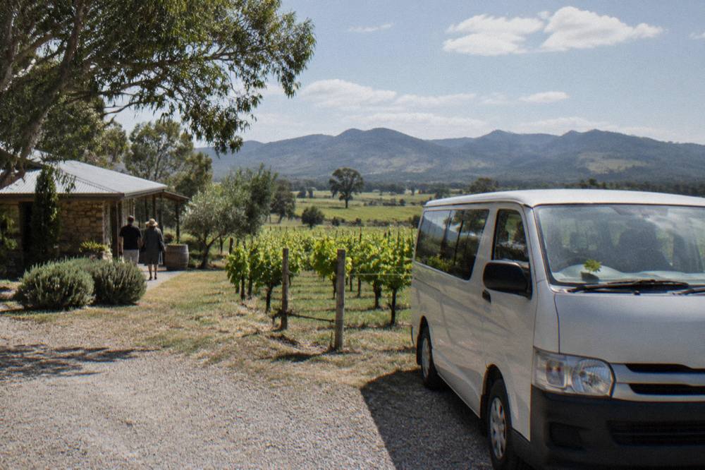 A small tour van parked beside a gravel driveway at a Hunter Valley cellar door