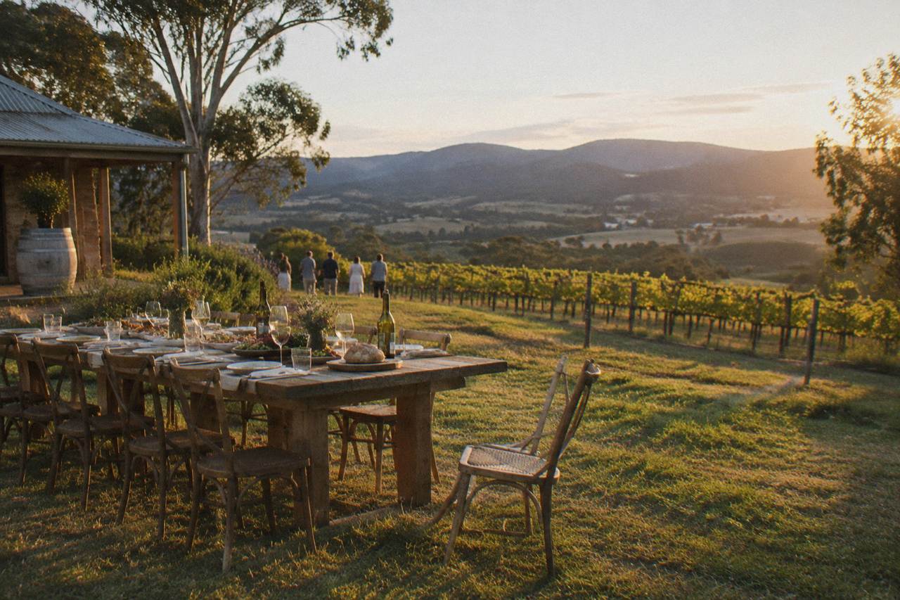 Long wooden table set for lunch overlooking rows of vines in the Hunter Valley
