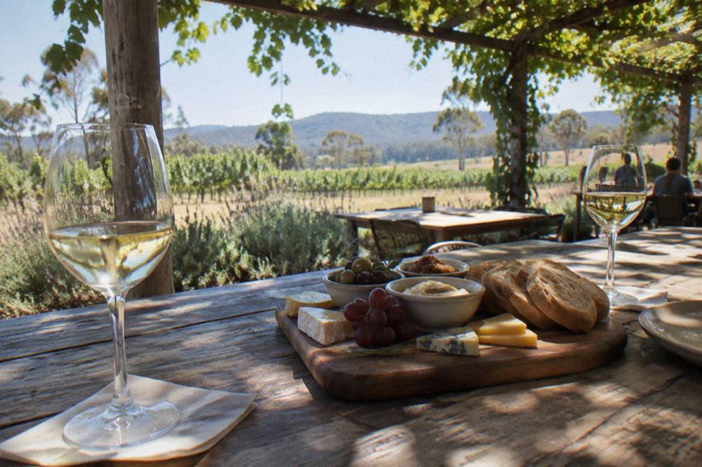 Grazing box of cheese, bread and dips on a wooden table at a winery