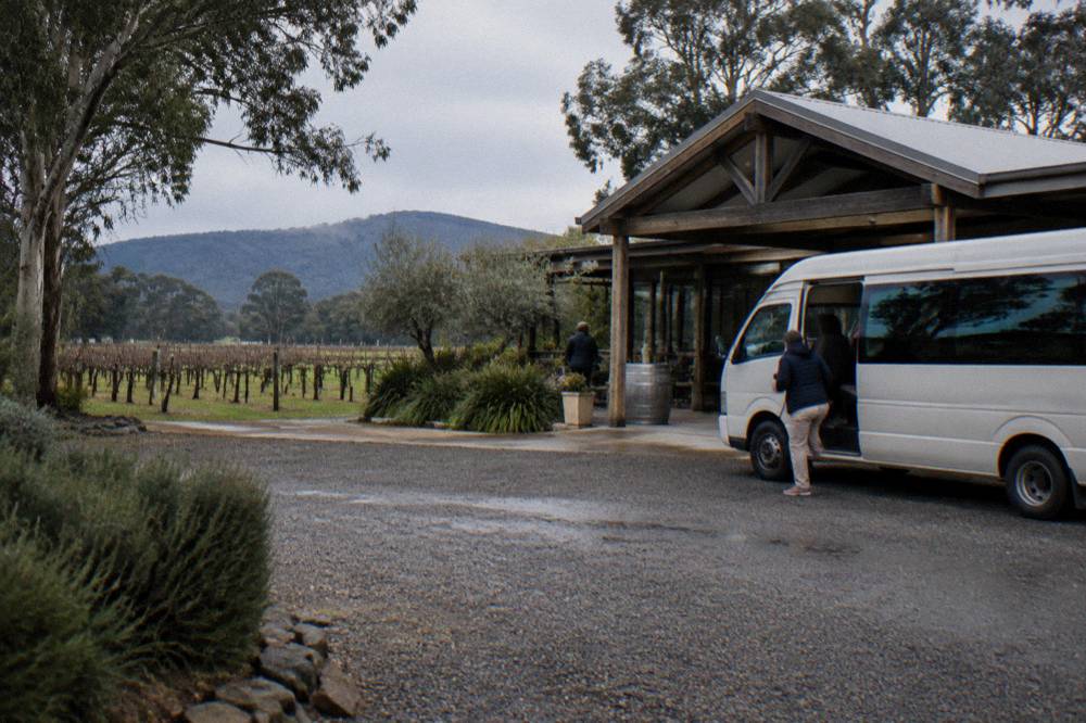 A small tour minibus parked beside a Hunter Valley cellar door entrance